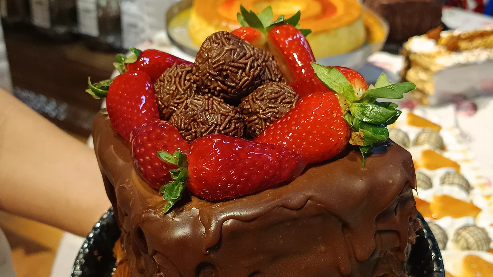 Bolo de chocolate com morangos e brigadeiros, feito na confeitaria do Megamix